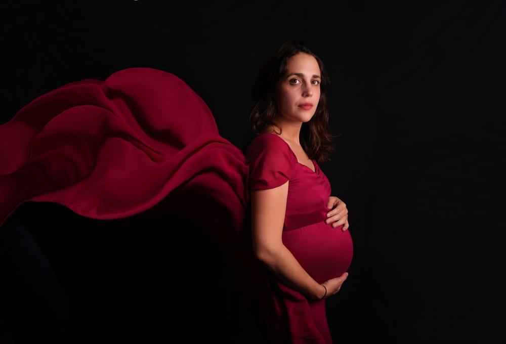 Séance grossesse en studio, drapé rouge déployé